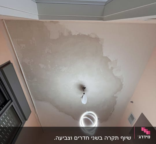 תקרה עם סימני רטיבות ונברשת עגולה